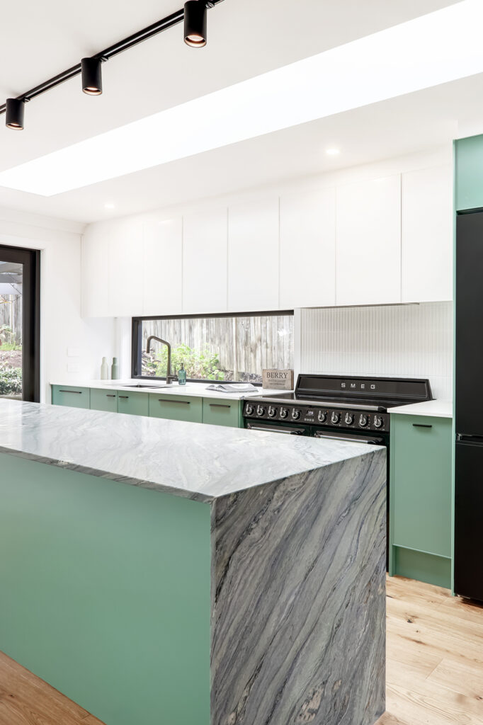 A stylish modern coastal kitchen in Freshwater built by Hoverco, featuring sleek white cabinetry, a marble island, and integrated appliances.