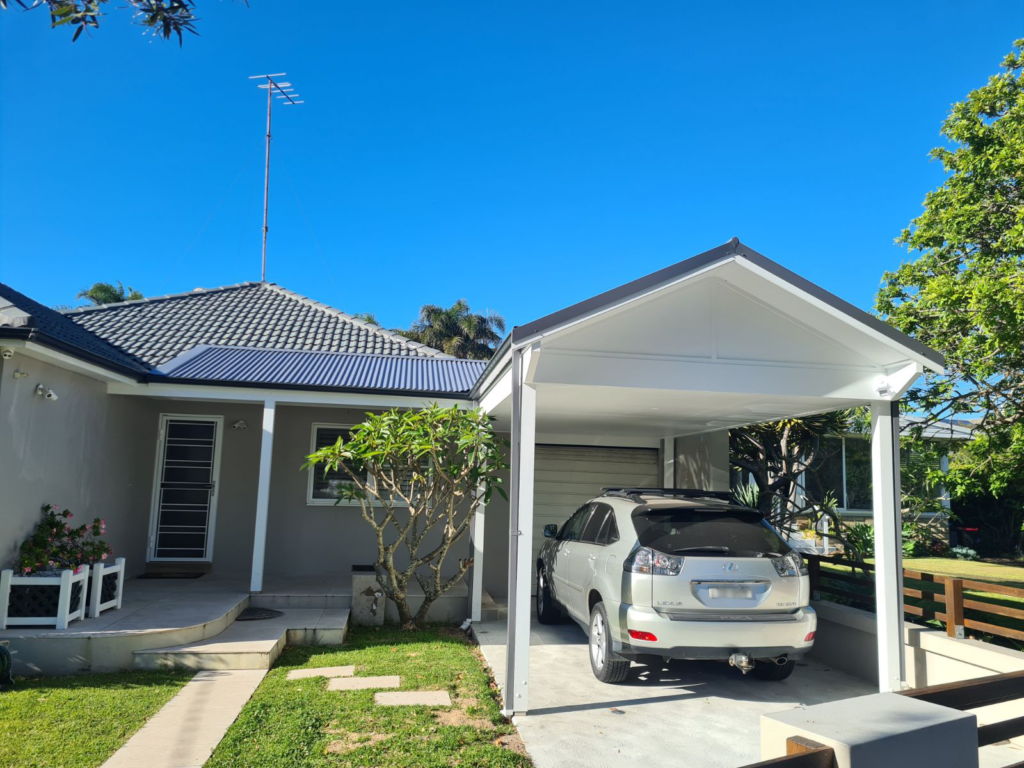 A custom-built steel carport installation by HoverCo, providing durable and stylish protection for vehicles in a modern residential setting.